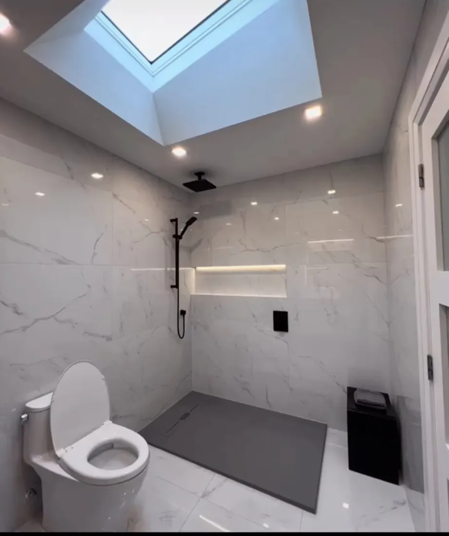 Bathroom with white marble-look tile walls and a walk-in shower